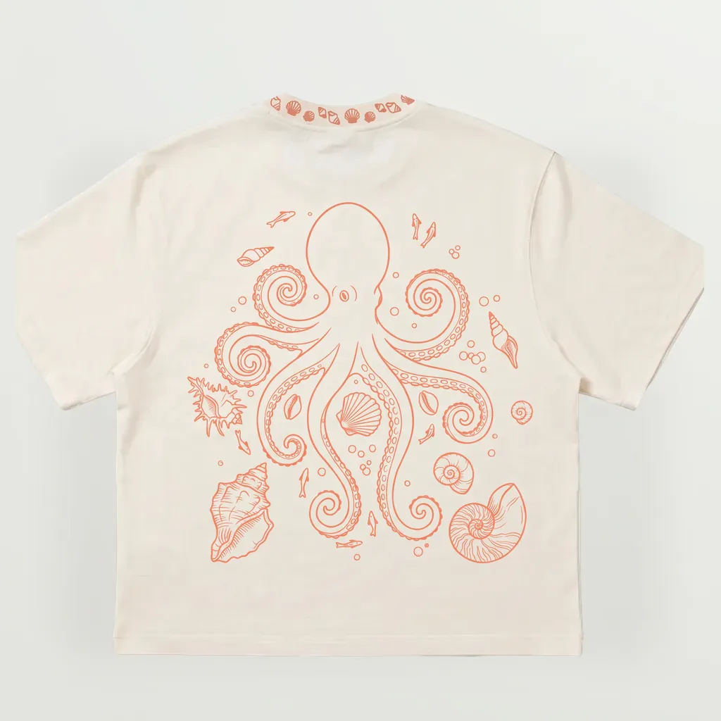 Mockup of the octopus tee, back: the octopus among shells, small fish and bubbles, in coral line art on cream