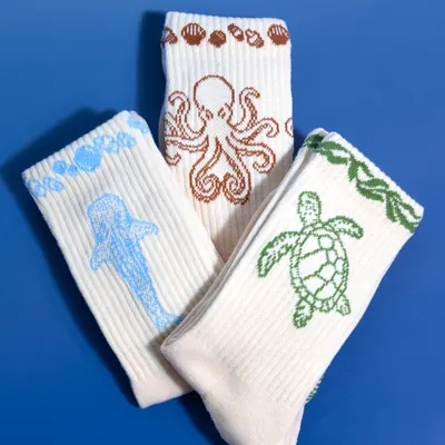 The octopus, turtle and whale shark socks fanned out on a blue background